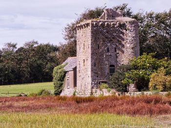 Old building on field against skysky. stone tower house