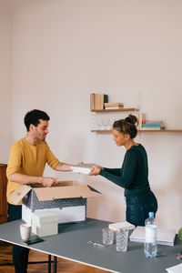 Mid adult couple unpacking books at new home