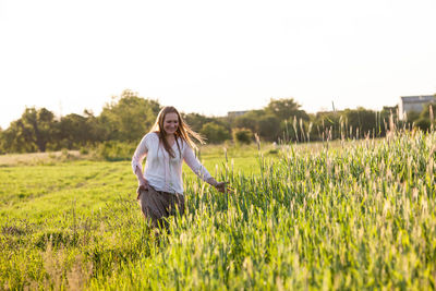 Full length of young woman standing in farm