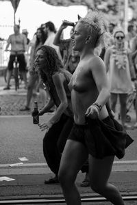 Rear view of shirtless man with woman on street