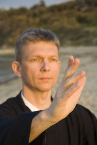 Close-up of man practicing tai chi at beach