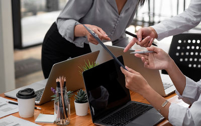 Midsection of people working on table