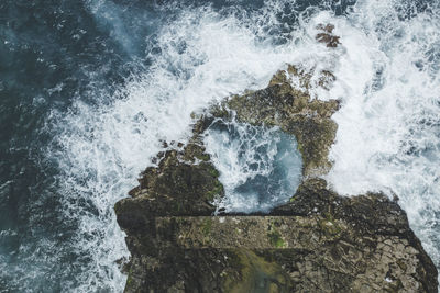 High angle view of waves splashing on rocks