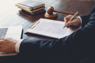 High angle view of man reading book on table