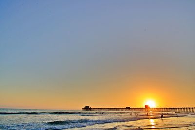 Scenic view of sea against clear sky during sunset