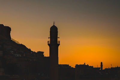 Silhouette buildings against sky during sunset