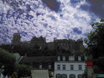 Low angle view of buildings against cloudy sky