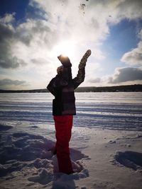 Full length of man standing on beach against sky during winter