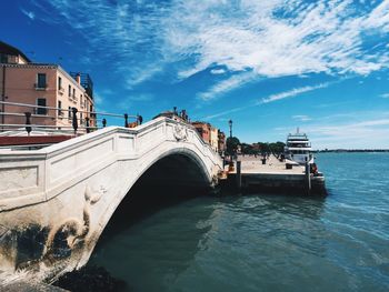 Arch bridge over water against sky