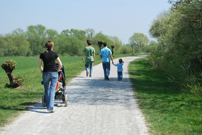 Full length of father and son walking on grassland