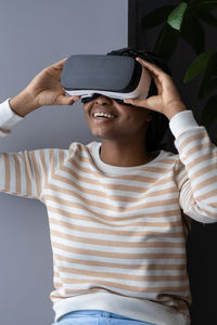 Overjoyed ecstatic young black lady testing modern innovative vr headset