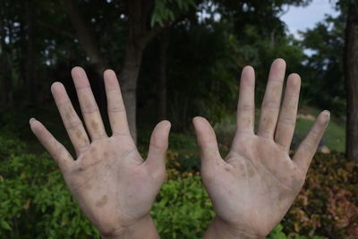 Cropped image of person showing dirty hands at park