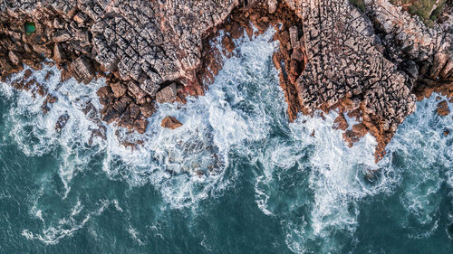 Directly above shot of rock formation by sea
