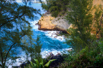 Scenic view of rocks by sea against sky