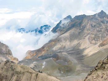 Scenic view of mountains against cloudy sky