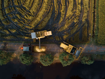 High angle view harvesters transferring harvest into a lorry 