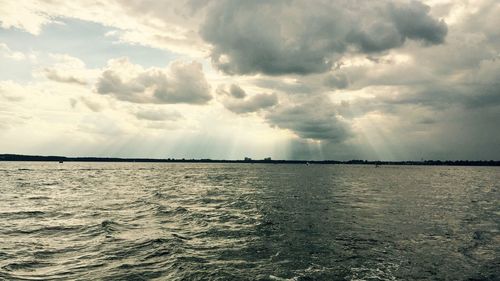 Scenic view of sea against storm clouds