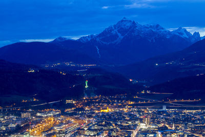 Aerial view of illuminated cityscape against sky at night