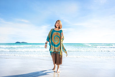 Man standing at beach against sky