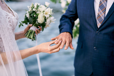 Midsection of bride holding bouquet