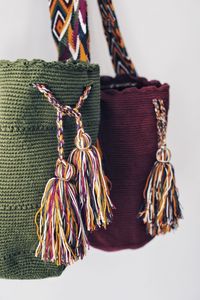 Close-up of multi colored tied hanging on rope against white background