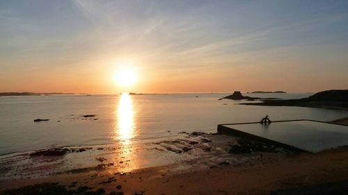 View of calm beach at sunset