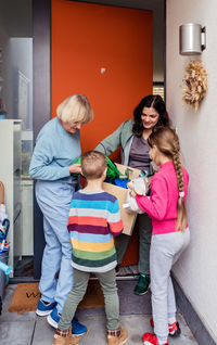 Woman help ukrainian refugees family with children fleeing from ukraine giving them clothes and toys