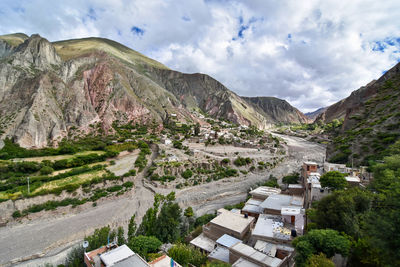 Panoramic shot of road by buildings against sky