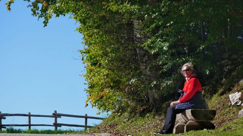 Rear view of woman sitting on footpath