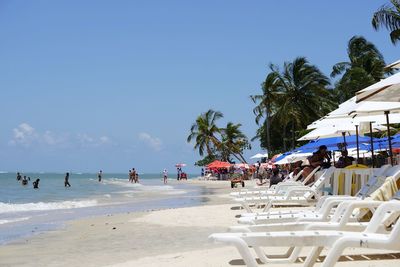 People on beach against blue sky