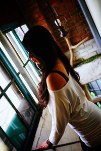 High angle view of woman standing by window at home