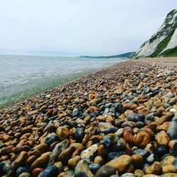 Pebbles on beach against sky