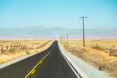 Empty road amidst land