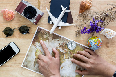 High angle view of hand holding smart phone on table