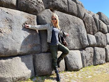 Full length portrait of young woman on rock