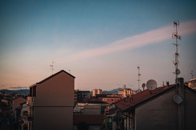 Buildings in city against sky during sunset