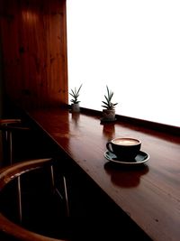 Coffee and potted plant on table