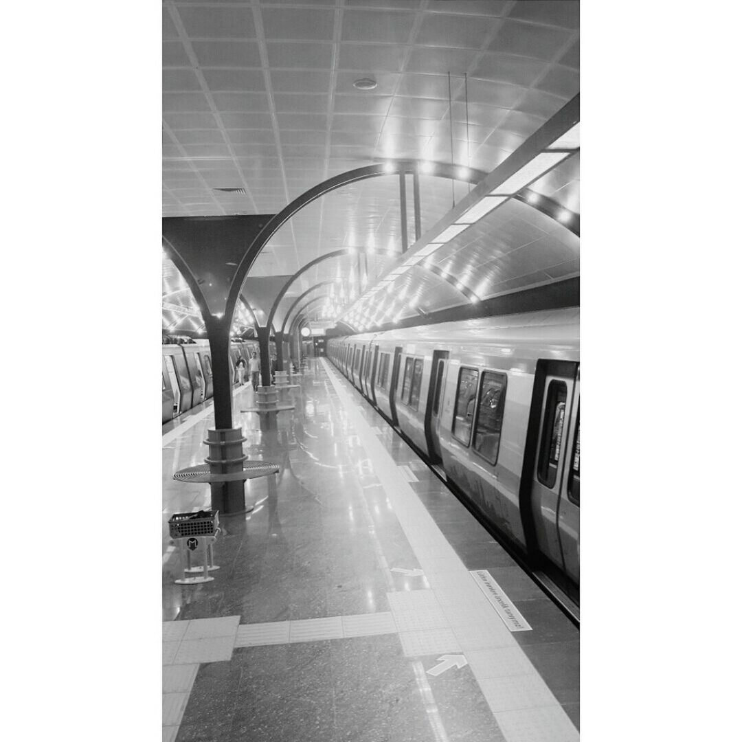 indoors, transportation, the way forward, architecture, built structure, ceiling, public transportation, railroad station platform, diminishing perspective, railroad station, empty, rail transportation, travel, illuminated, railroad track, mode of transport, interior, vanishing point, subway station, architectural column