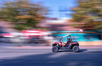 Side view of man riding motorcycle on street