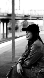 Smiling young woman sitting outdoors