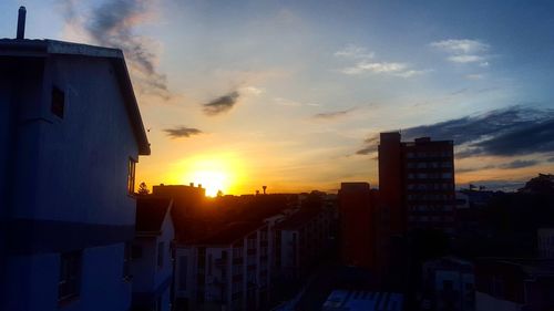 Silhouette buildings against sky during sunset