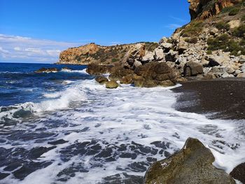 Scenic view of rocks in sea against sky