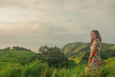 Woman standing by sea against sky