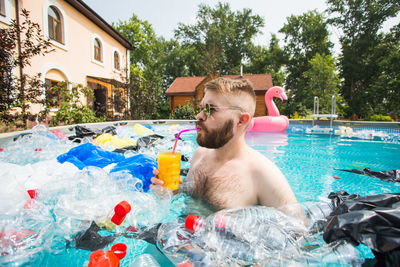 Full length of shirtless man in swimming pool