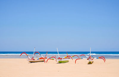 Deck chairs on beach against clear blue sky