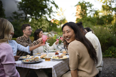 Portrait of smiling friends sitting on table
