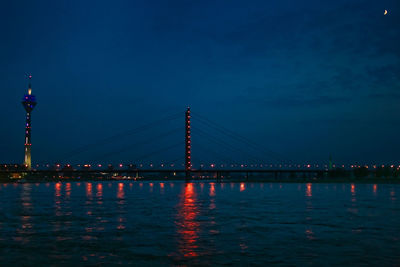 Illuminated suspension bridge over river at night