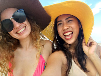 Portrait of cheerful friends wearing hat outdoors