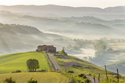 Tuscan farm landscape with morning fog in the rolling landscape