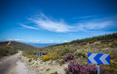 Road signs on landscape against blue sky